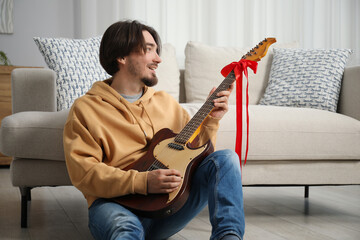 Dreams come true. Happy man with guitar at home