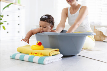 Mom bathing her little baby at home, closeup