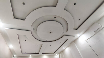 Modern gypsum ceiling design with elegant geometric patterns and recessed lighting. This interior shot is perfect for showcasing architecture, home decoration, and construction projects. Ideal for des