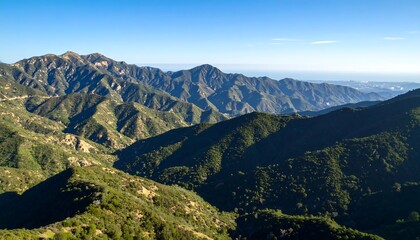 Naklejka premium Mountain vista, lush green slopes, clear blue sky