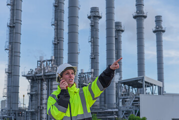 workers or engineers review plans at industrial site