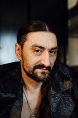 portrait of a handsome man with dark hair and a black beard