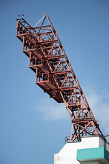 Metal crane structure reaching toward the sky at construction site during bright sunny day