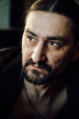 portrait of a handsome man with dark hair and a black beard