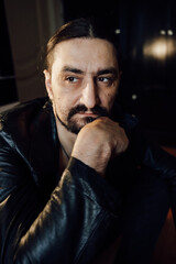 portrait of a handsome man with dark hair and a black beard