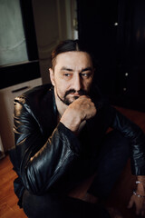 portrait of a handsome man with dark hair and a black beard