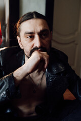portrait of a handsome man with dark hair and a black beard