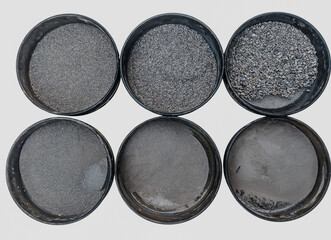 Isolated photo of sand sieve analysis test with different particle sizes in round metal sieves on white background, construction and laboratory concept.
