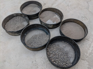 Laboratory sand sieve analysis showing different grain sizes separated in metal sieves for...