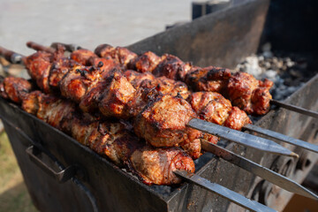 Shashlik on skewers on grill, barbecue meat cooking outdoors