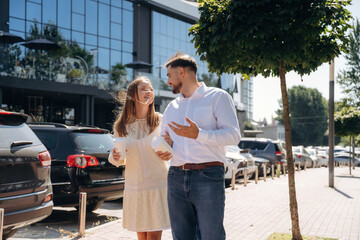 Cups of drinks in hands. Happy couple together outdoors