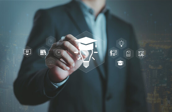 Businessman touching virtual education icons with graduation cap and light bulb, symbolizing online learning, digital knowledge, innovation, e-learning technology, future education development concept