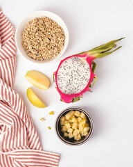 Dragon fruit half with diced apple and buckwheat on rustic white background