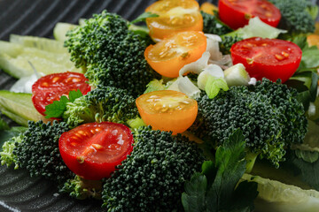 Closeup fresh salad with broccoli, cucumbers and cherry tomatoes