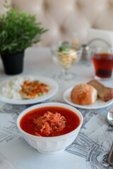 Dining table with borscht, rice with fish and bread assortment