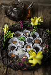 Assorted chocolates in box with tea and flowers inside decorative wreath