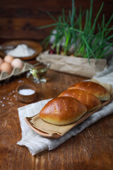 Golden brown baked buns on tray with rustic cloth and warm lighting