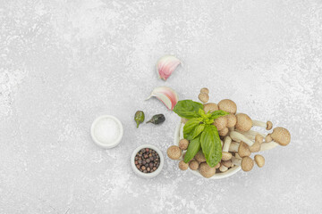 Fresh assorted shimeji mushrooms with olive oil, basil, garlic, salt, pepper on rustic background