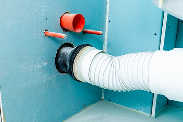 In a house being renovated, a toilet opening for a new closet was made in the plasterboard wall.