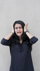 A young cute girl closes her eyes and ears, showing the playful innocence of the see no evil and...