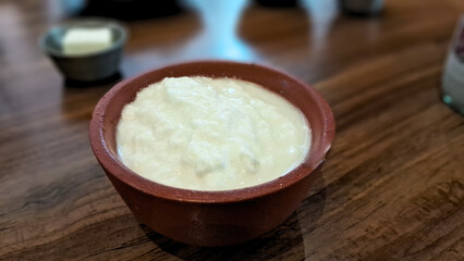 A small mud pot holds creamy curd, showcasing traditional charm and rustic simplicity in every wholesome serving