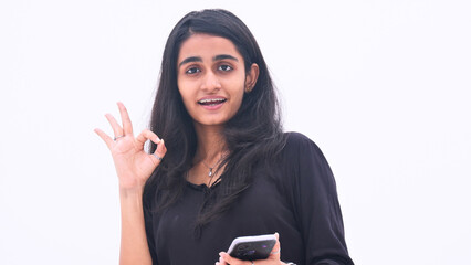 A young girl gestures with her fingers, expressing beauty and wonder against a pure white...