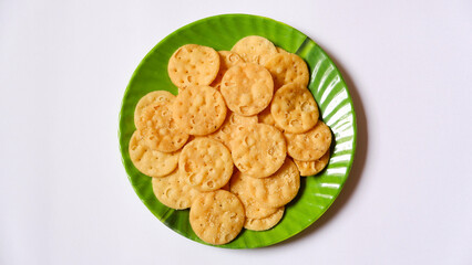 Green plate filled with crispy puris, ideal for showcasing Indian snacks, street food, or traditional cuisine concepts.