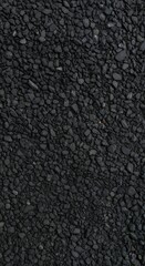 Fototapeta premium Close-up texture of black gravel stones, dark crushed rock surface background, perfect for construction, architecture, flooring, and natural abstract design concepts