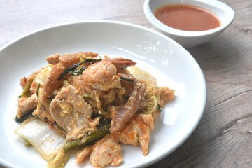 fried seafood with chicken and pork meat couple glass noodles vegetable toping egg yolk dipping sukiyaki sauce on plate