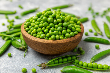 Fresh green pea pods with green peas on a wooden background. Sweet green peas. Green pea beans vegetables. Vegan. healthy vegetable. Copy space