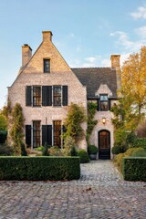 Nestled in a peaceful neighborhood, this charming brick house is embraced by vibrant greenery, creating a picturesque scene on a sunny autumn afternoon