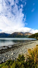 Picturesque lake shore with mountains and clouds