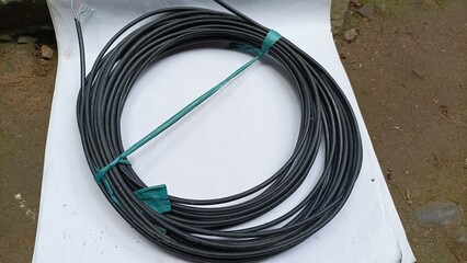 power supply cable, black cable roll on white board