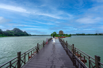 Teenage female tourist walking across the bridge to the beautiful Chua Vàng (Golden Temple) in the...