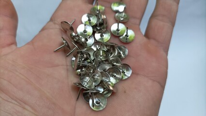 Some tacks in hand with silver color