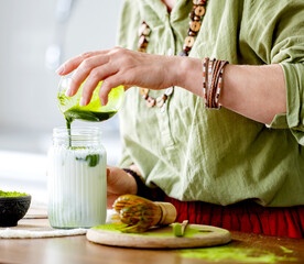 Woman Preparing Matcha Green Tea Adding Tea To Milk For A Matcha Latte Close-Up