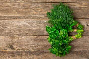 Dill and parsley on the texture table. Mixed bunch of fresh parsley and dill. Fresh aromatic spicy greens. Spices and herbs. Space for text. Copy space