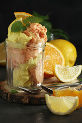 Lemon and orange ice cream scoops in glass jar