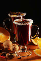 Two cups with ready mulled wine with anise, cinnamon and nuts around