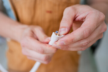 Close-up of electrician's hands carefully connecting wires of electric stove cable during home...