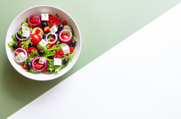 Greek salad with feta cheese, tomatoes, onion, cucumbers, peppers and olives. Healthy eating. Vegetarian food.