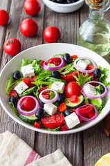 Greek salad with feta cheese, tomatoes, onion, cucumbers, peppers and olives. Healthy eating. Vegetarian food.