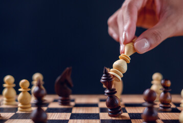 male hand moving chess piece on chess board game, business success, business competition planning...