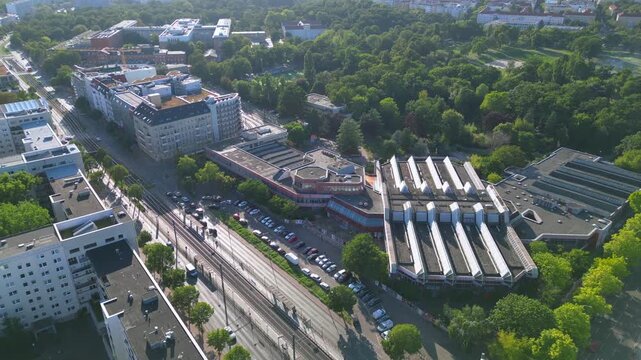 Sez and Volkspark Friedrichshain in Berlin, showcasing its lush greenery, a passing tram on a sunny day. speed ramp hyper motion time lapse Magic aerial view flight wide orbit overview drone