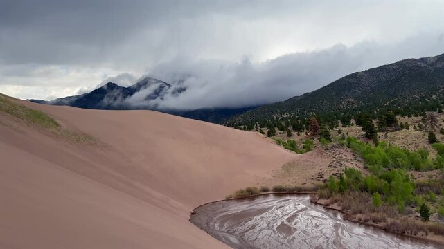 Medano Creek Great Sand Dunes National Park Sangre de Cristo range Rocky Mountains spring summer raining cloudy Colorado unique magical large amounts of sand dune hills windy landscape Crestone Needle