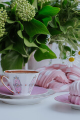 Elegant pink decoration featuring a delicate cup of coffee, surrounded by delicious desserts and fresh flowers, creating a delightful atmosphere for enjoying sweet moments