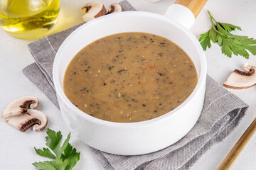 Delicious tasty champignons mushrooms cream soup. Creamy pureed vegetable soup with mushrooms, carrot, herbs. Autumn and winter comfort food, vegan diet recipe