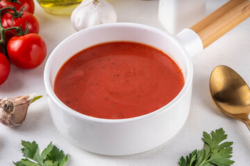 Tasty tomato cream soup. Delicious hot fall season gazpacho creamy pureed soup with garlic and aromatic herbs. Autumn and winter comfort food, tasty vegan vegetable recipe