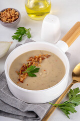 Cream of onion soup puree. White onion cream soup with crunchy caramelized fried onion topping. Autumn and winter comfort food, tasty vegan vegetable recipe