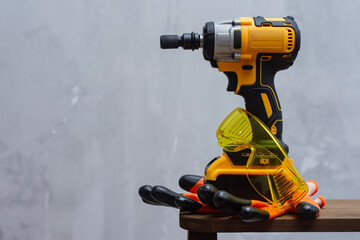 Cordless impact wrench with protective gloves and goggles. Tools for the job and protective...